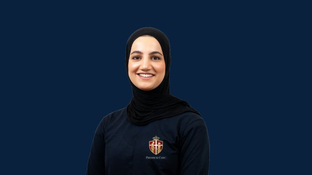 Bibi Naziyh Dowezai, administrerende direktør og grundlægger af Premium Care ApS, smilende i navy uniform med Premium Care-logo